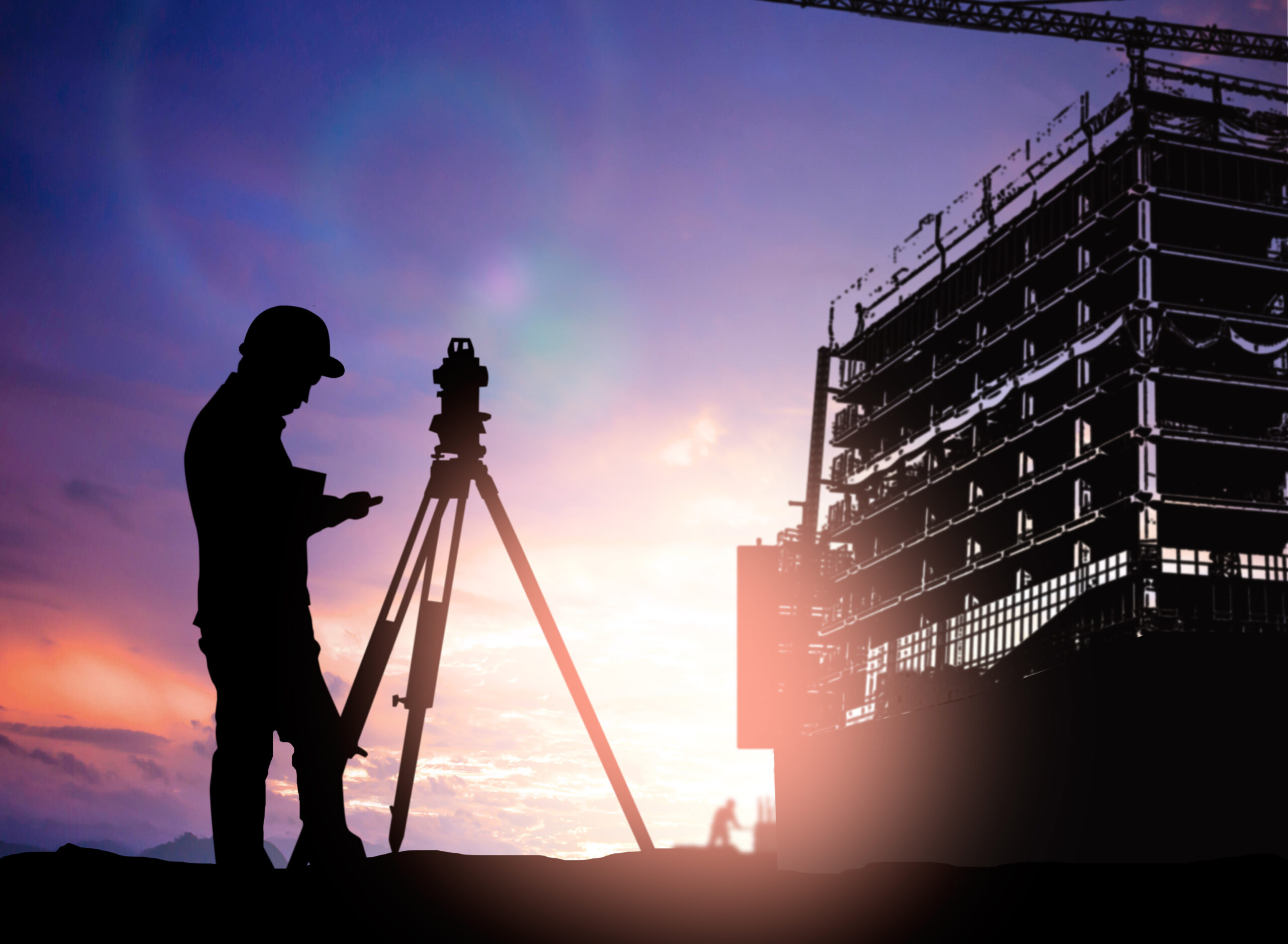 silhouette survey engineer working  in a building site over Blurred construction worker on construction site